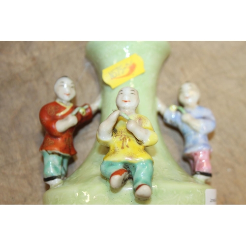 73 - A Chinese polychrome decorated figure of a man holding a sword, a green glazed wall pocket with reli... 