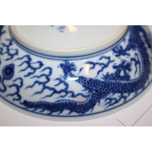 69 - Two Chinese blue and white dragon decorated dishes with six character marks to bases, similar plates... 