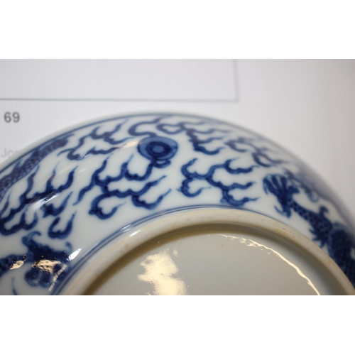 69 - Two Chinese blue and white dragon decorated dishes with six character marks to bases, similar plates... 