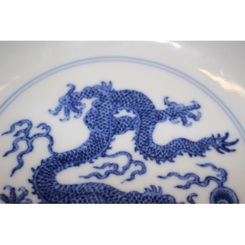 69 - Two Chinese blue and white dragon decorated dishes with six character marks to bases, similar plates... 