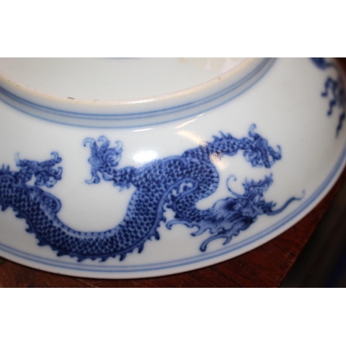 69 - Two Chinese blue and white dragon decorated dishes with six character marks to bases, similar plates... 