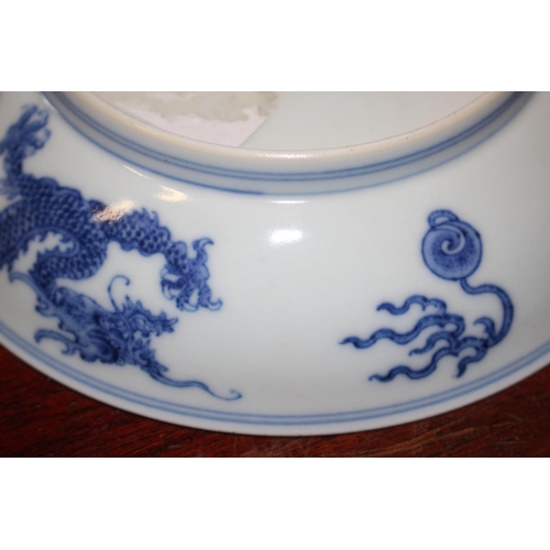 69 - Two Chinese blue and white dragon decorated dishes with six character marks to bases, similar plates... 