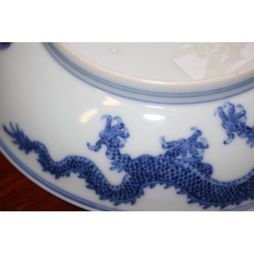 69 - Two Chinese blue and white dragon decorated dishes with six character marks to bases, similar plates... 