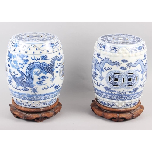 122 - A pair of Chinese blue and white miniature garden seats, decorated dragons and clouds, on hardwood s... 