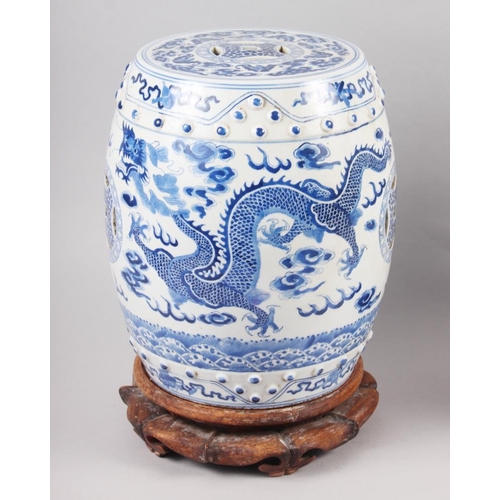 122 - A pair of Chinese blue and white miniature garden seats, decorated dragons and clouds, on hardwood s... 