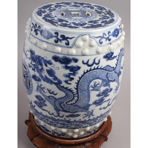 122 - A pair of Chinese blue and white miniature garden seats, decorated dragons and clouds, on hardwood s... 