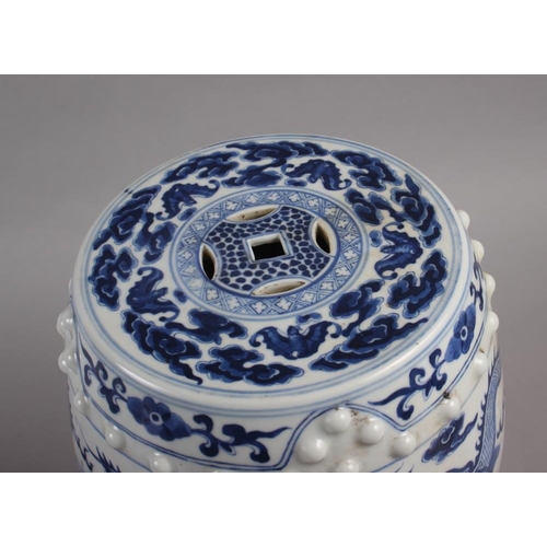 122 - A pair of Chinese blue and white miniature garden seats, decorated dragons and clouds, on hardwood s... 