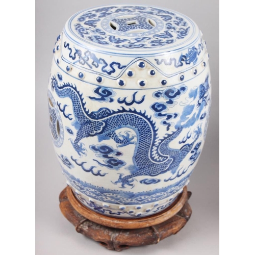 122 - A pair of Chinese blue and white miniature garden seats, decorated dragons and clouds, on hardwood s... 