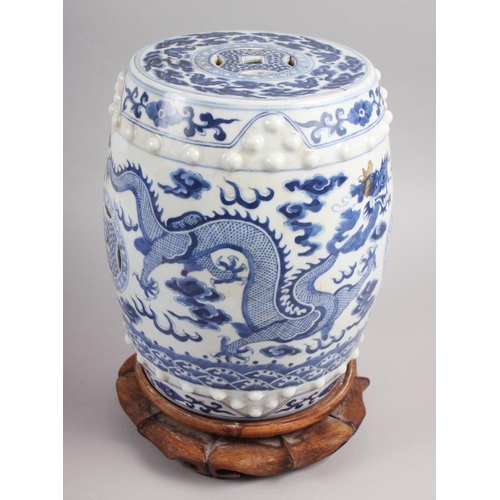 122 - A pair of Chinese blue and white miniature garden seats, decorated dragons and clouds, on hardwood s... 