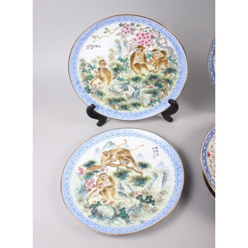 124 - A pair of Chinese plates, decorated monkeys in a landscape with character marks to base, 10 1/4