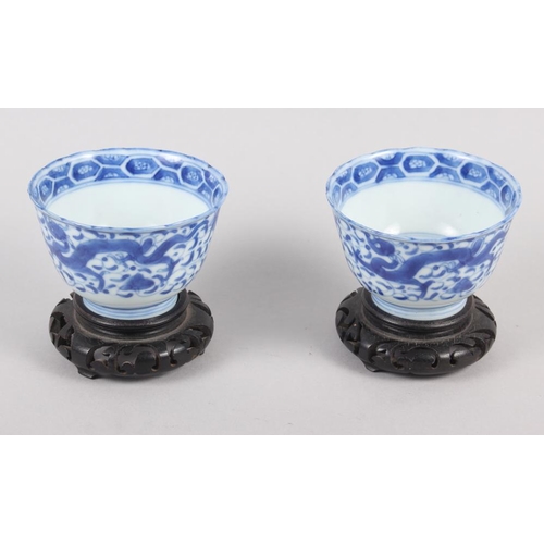 126 - A pair of Chinese blue and white tea bowls, decorated dragons and phoenix with four character marks ... 