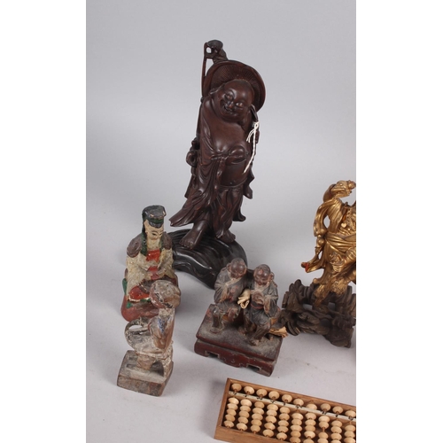 143 - A quantity of Chinese carved figures, including a figure of Buddha and an abacus