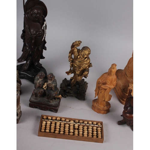 143 - A quantity of Chinese carved figures, including a figure of Buddha and an abacus