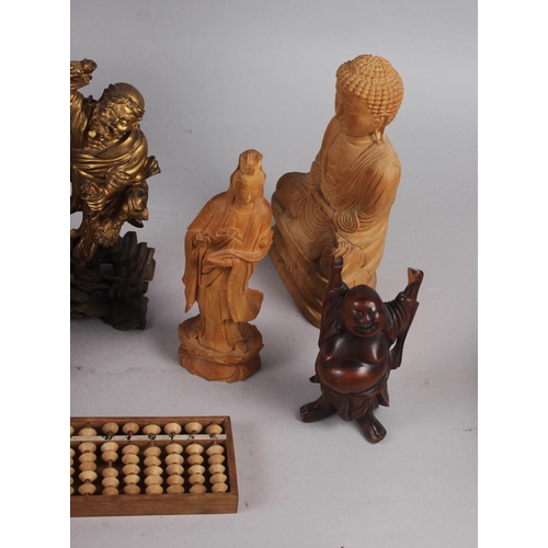 143 - A quantity of Chinese carved figures, including a figure of Buddha and an abacus