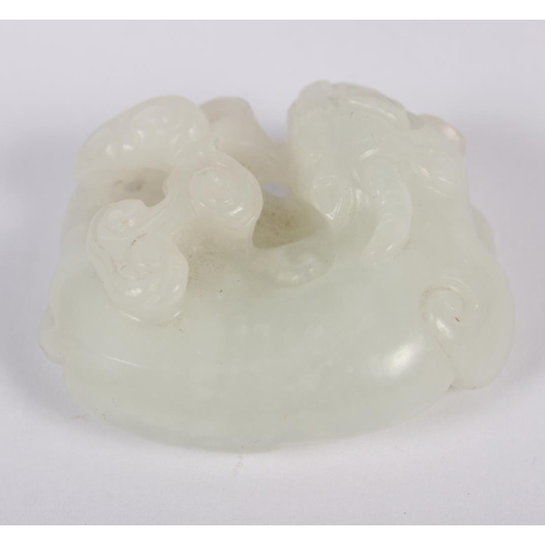 150 - A Chinese celadon jade carving of a recumbent Kylin and clouds, 1 1/2