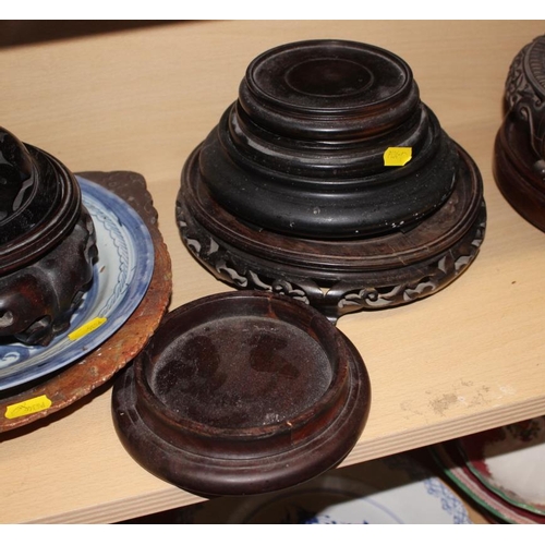 158 - A quantity of hardwood stands and vase covers, a Chinese blue and white dish and a soapstone dish