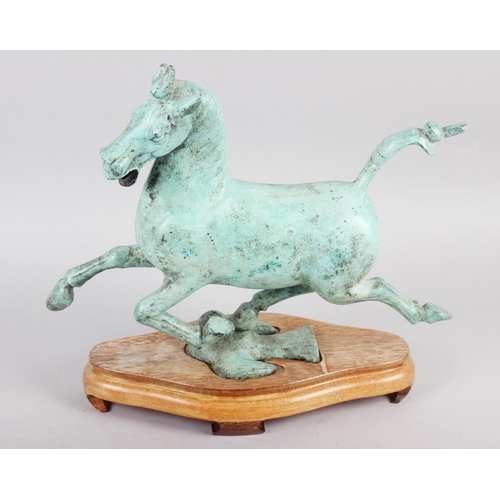 192 - A patinated bronze model of the flying horse of Kansu, on hardwood stand, 10 1/2