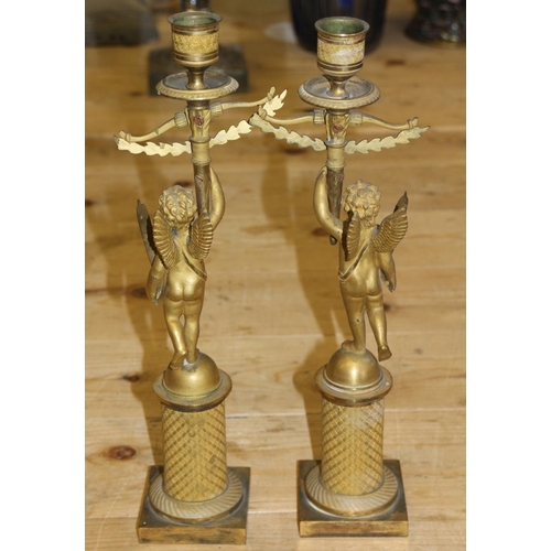 194 - A pair of 19th century Italian gilt brass single light table candlesticks, formed as cherubs with la... 