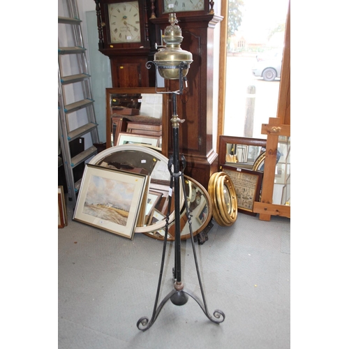 202 - An Edwardian brass oil lamp, on black metal stand with tripod base, 60