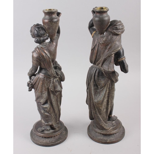 205 - A pair of spelter figure candlesticks, Middle Eastern/Nubian figures carrying oil jars, 14 1/2