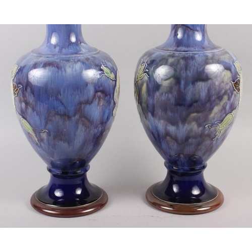 22 - A pair of Royal Doulton blue glazed vases with flared tops and ovoid bodies, tub lined decoration of... 