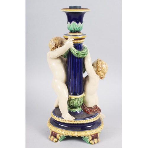 26 - A Minton majolica candlestick with amorini, 12 1/2