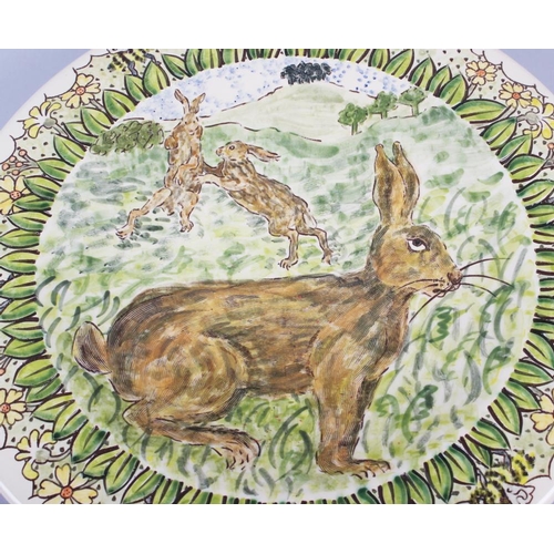 28 - A studio pottery charger with sgraffito decoration of hares, 14 1/2