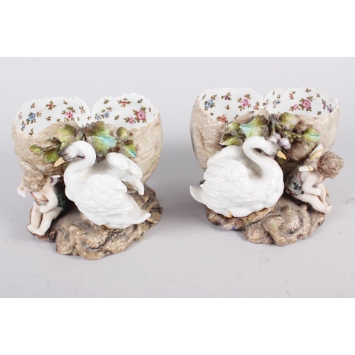 31 - A pair of continental porcelain spill vases, formed as swans with cherubs, 3 1/2