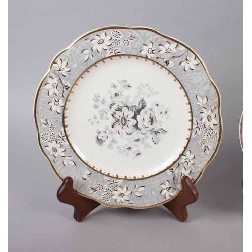 4 - A pair of Rockingham porcelain dessert plates with grey and gilt decorated floral borders and centra... 