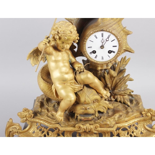 163 - A French gilt mantel clock with white enamel dial, Roman numerals and putto, fish and shell decorati... 