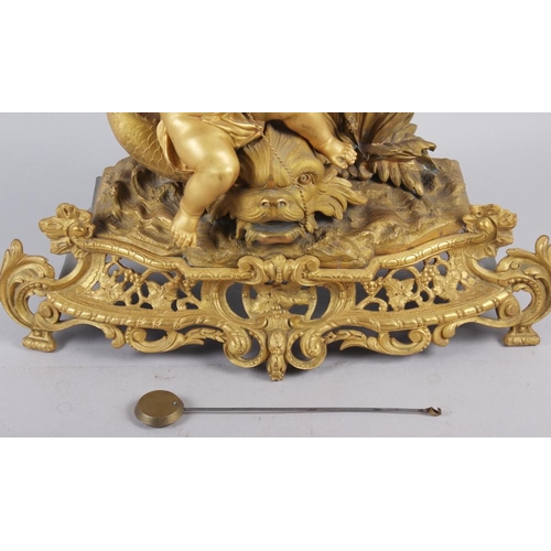 163 - A French gilt mantel clock with white enamel dial, Roman numerals and putto, fish and shell decorati... 