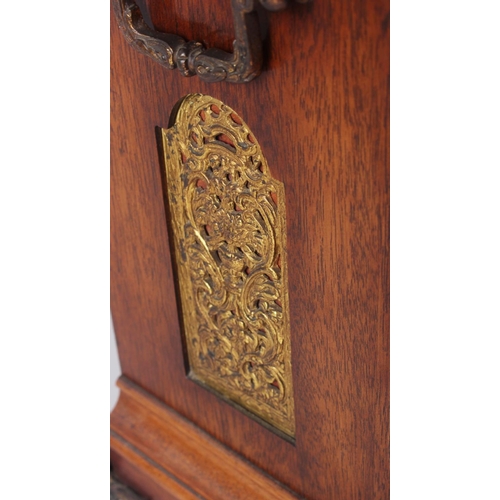 170 - An oak cased mantel clock with brass relief decoration, on brass scrolled supports, 16 1/2