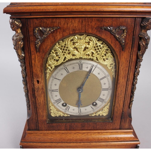 170 - An oak cased mantel clock with brass relief decoration, on brass scrolled supports, 16 1/2