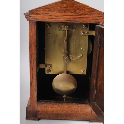 171 - An oak cased mantel clock with silvered dial, etched 