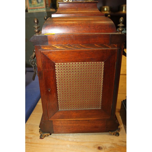 170 - An oak cased mantel clock with brass relief decoration, on brass scrolled supports, 16 1/2