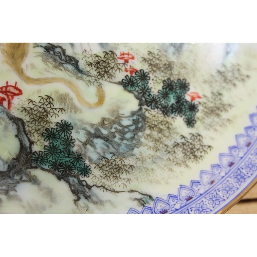 124 - A pair of Chinese plates, decorated monkeys in a landscape with character marks to base, 10 1/4