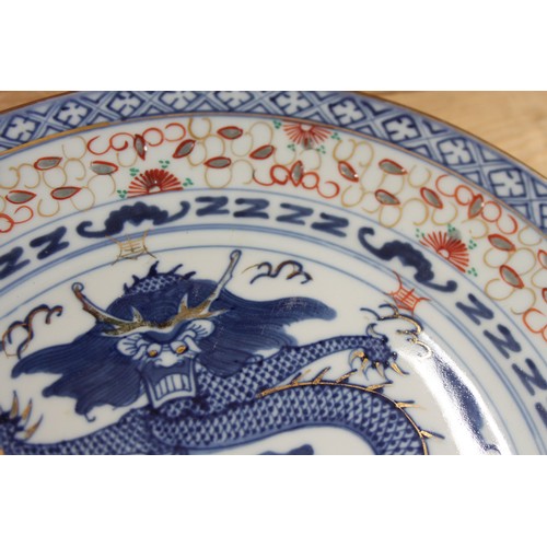 124 - A pair of Chinese plates, decorated monkeys in a landscape with character marks to base, 10 1/4