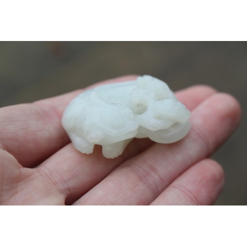 150 - A Chinese celadon jade carving of a recumbent Kylin and clouds, 1 1/2