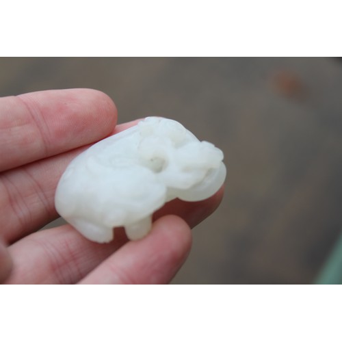 150 - A Chinese celadon jade carving of a recumbent Kylin and clouds, 1 1/2