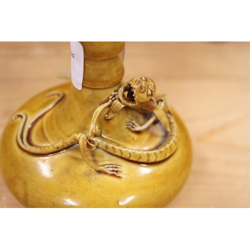 129 - A 19th century Chinese yellow glazed pottery squat baluster vase, decorated with a sinuous dragon in... 