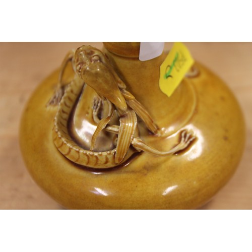 129 - A 19th century Chinese yellow glazed pottery squat baluster vase, decorated with a sinuous dragon in... 