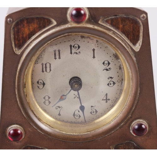 110 - An Art Nouveau walnut and copper mounted mantel clock with three garnet coloured cabochons and silve... 