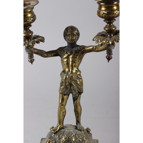 129 - A pair of 19th century brass Nubian figure two-light candlesticks, on square bases, 9