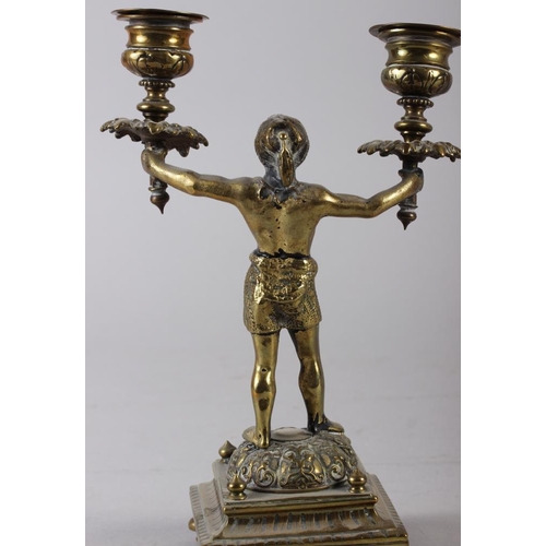 129 - A pair of 19th century brass Nubian figure two-light candlesticks, on square bases, 9