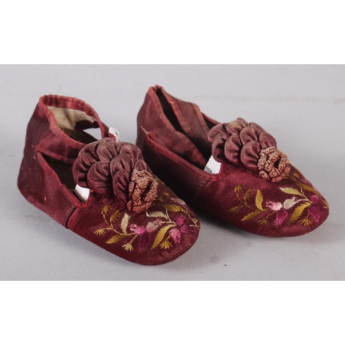 163 - An infant's pair of silk and embroidered shoes, in display case, 7 1/4