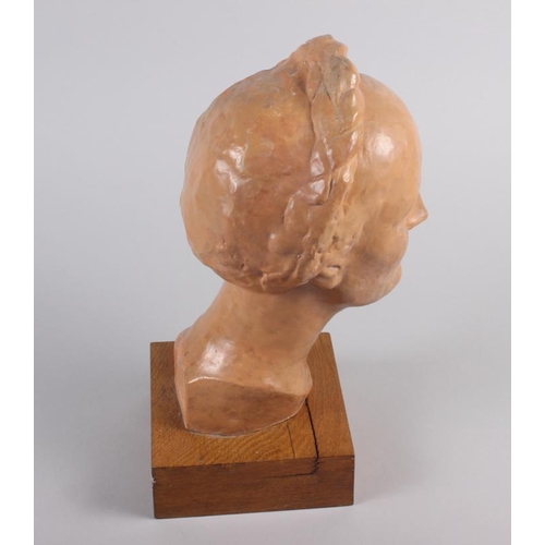 172 - A 1930s terracotta portrait bust of a woman with a long plait, 13