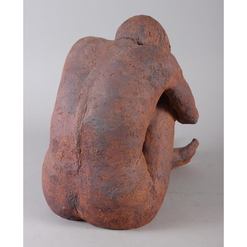 184 - A stoneware sculpture of a crouching nude figure, 11