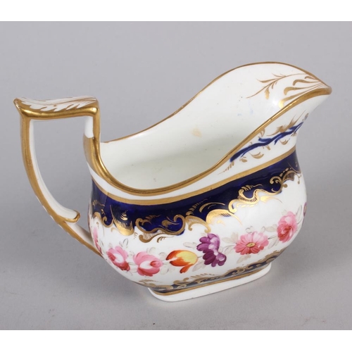 26 - A Daniels type floral gilt decorated cream jug and a blue and floral panel decorated milk jug