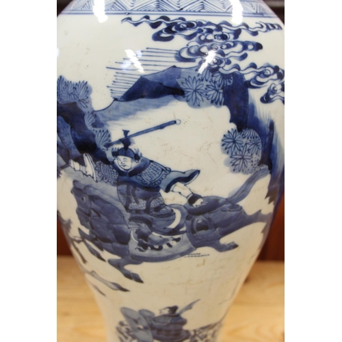 91 - A 19th century Chinese blue and white baluster vase, decorated warriors on horseback, 19 1/2