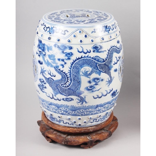 93 - A pair of Chinese blue and white miniature garden seats, decorated dragons and clouds, on hardwood s... 